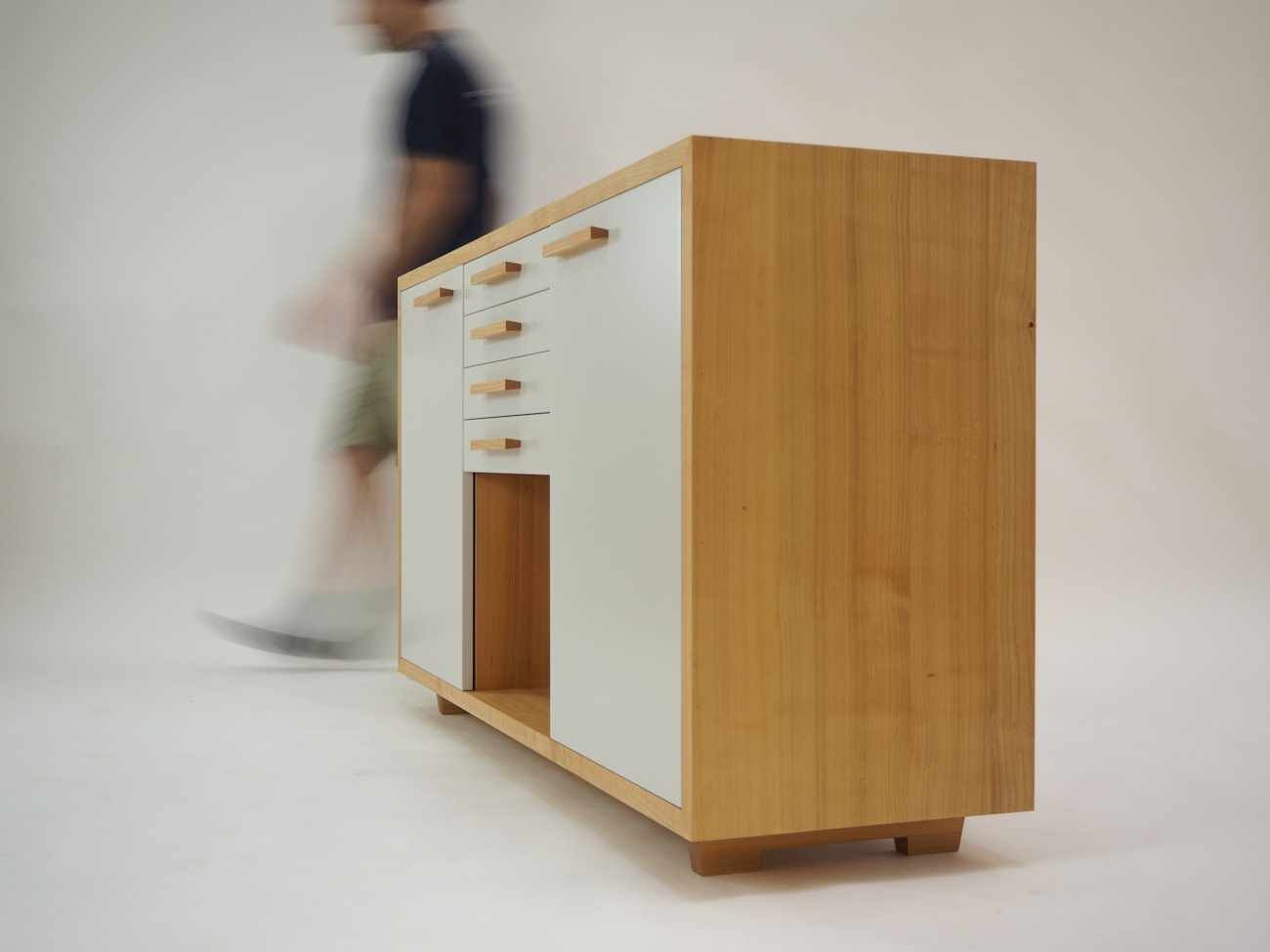 A mover carefully carrying a wrapped piece of furniture